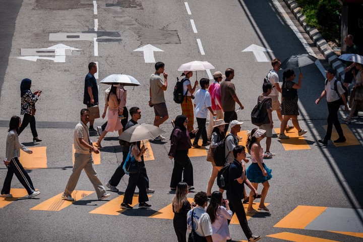 La gente utiliza paraguas y ventiladores eléctricos para refrescarse en Kuala Lumpur. Foto: Syaiful Redzuan / Anadolu/ AFP