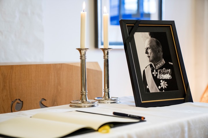 Un retrato de Harald V y un cuaderno para dejar mensajes en memoria del fallecido rey de Noruega. Foto EFE