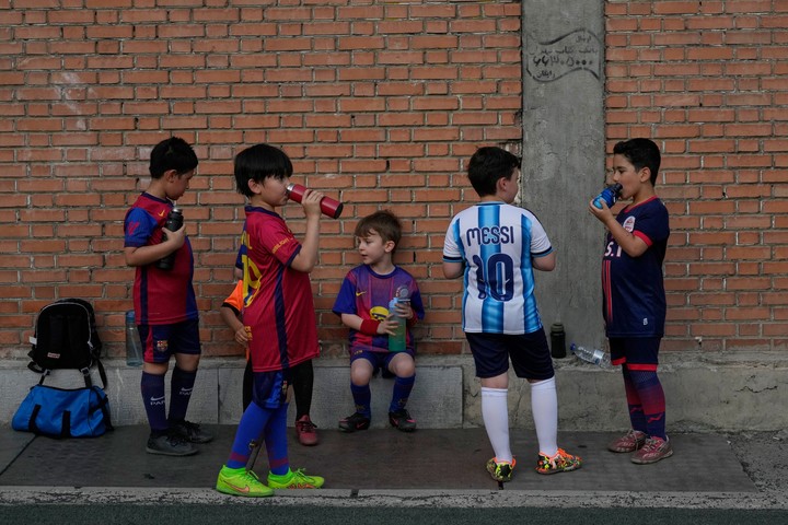 Niños iraníes durante un descanso en medio de una práctica de fútbol en Teherán. Foto: AP